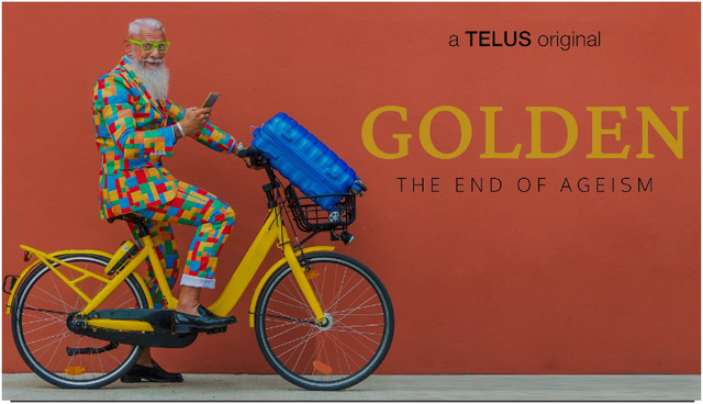 A man in a colorful suit on a yellow bicycle with a blue suitcase in the basket. In the background is an orange wall. Beside the man is the text "A TELUS original. Golden The End of Ageism"