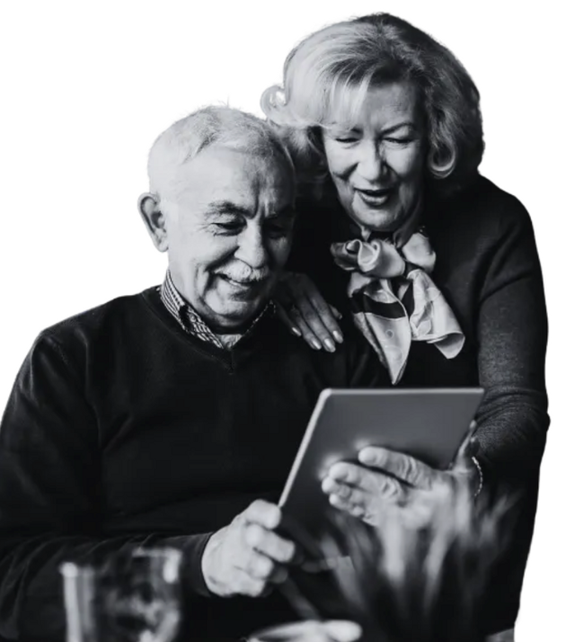 Two olders look over a tablet in a black and white photo