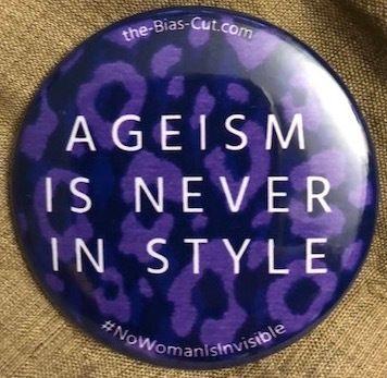 A black and purple button with the text "Ageism is Never in Style" in the center. Above this is the web addresss the-bias-cut.com and below it a hashtag that says "No Woman is Invisible"